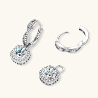 Sterling silver twisted hoop earrings with round moissanite stones in halo settings against neutral background.