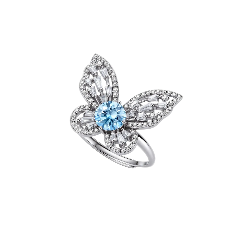 Sterling silver ring with blue moissanite center stone surrounded by clear stones in butterfly wing pattern on white background