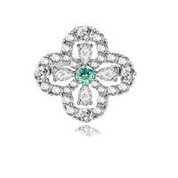 Sterling silver adjustable ring featuring four-leaf clover design with green center moissanite and clear accent stones