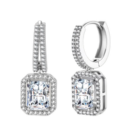 Sterling silver huggie hoops with emerald-cut moissanite drops featuring pavé-set crystals on white background.