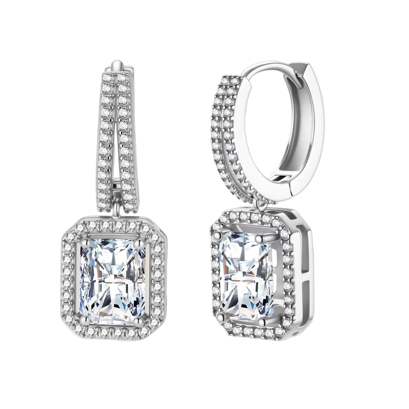 Sterling silver huggie hoops with emerald-cut moissanite drops featuring pavé-set crystals on white background.