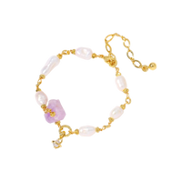 Gold-plated bracelet with lustrous baroque pearls and raw lavender amethyst centerpiece on white background.