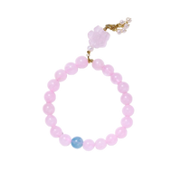 Stretchy beaded bracelet with pink rose quartz, blue aquamarine, carved floral pendant, and pearl tassel clasp.
