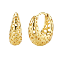 Close-up of small gold-plated hoop earrings with intricate honeycomb cutout pattern on cream background.