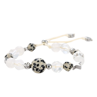 Adjustable beaded bracelet with spotted dalmatian stones, clear quartz crystals, and silver star charm on white background.