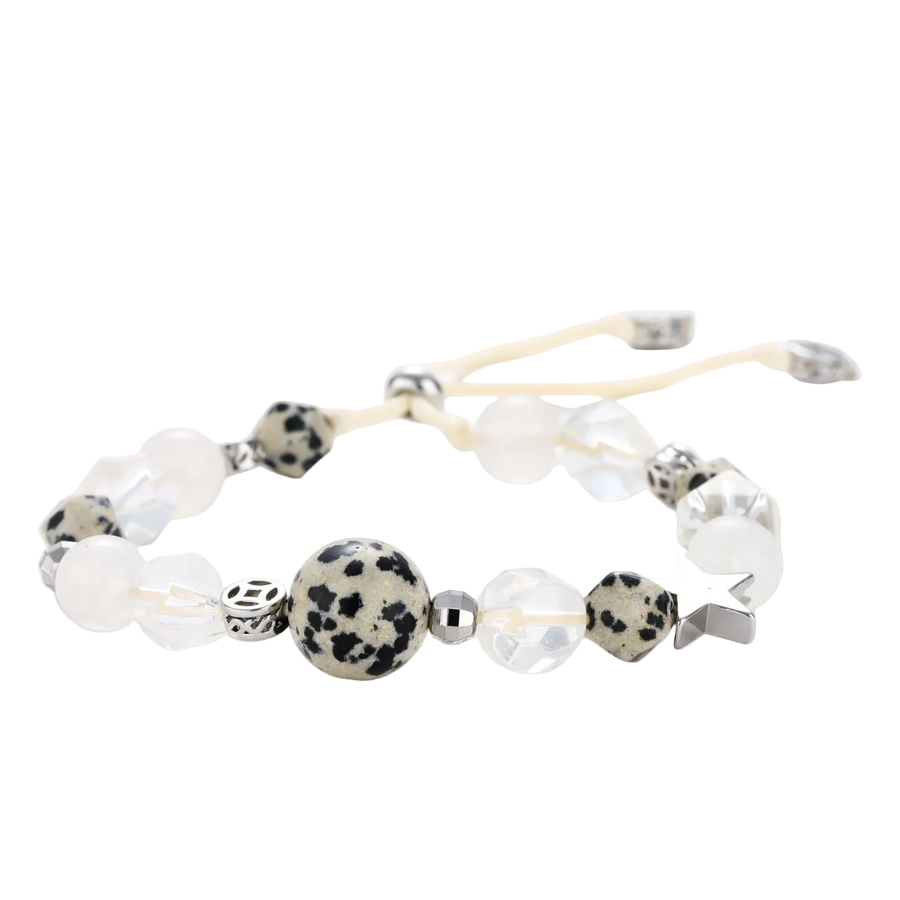 Adjustable beaded bracelet with spotted dalmatian stones, clear quartz crystals, and silver star charm on white background.