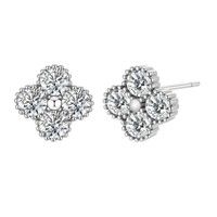 Dainty sterling silver quatrefoil stud earrings with four brilliant moissanite stones and center accent on white background.