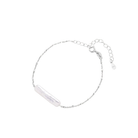 Minimalist bracelet with iridescent baroque pearl on rhodium-plated sterling silver chain against cream background