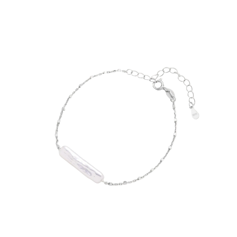Minimalist bracelet with iridescent baroque pearl on rhodium-plated sterling silver chain against cream background