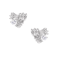 Pair of sculptural white gold-plated stud earrings with twisted ribbon design and sparkling zirconia stones on cream background