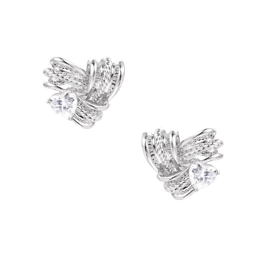 Pair of sculptural white gold-plated stud earrings with twisted ribbon design and sparkling zirconia stones on cream background