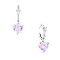 Silver huggie hoops with pink heart-cut zirconia pendants on white background, eco-friendly white gold plated brass