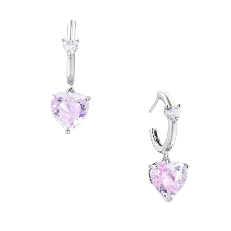 Silver huggie hoops with pink heart-cut zirconia pendants on white background, eco-friendly white gold plated brass