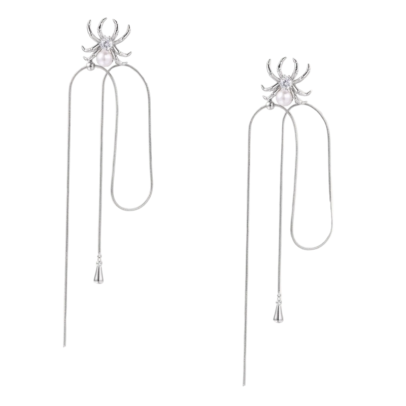 White gold plated spider earrings with pearl body and long threader chains on beige background
