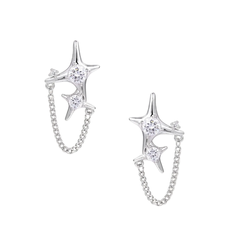 Silver star studs with crescent moon cutouts and zirconia stones connected by delicate chains on white background