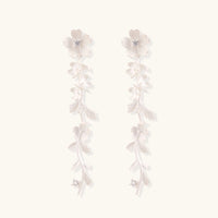 Long sterling silver drop earrings with delicate floral vine design and crystal accents on white background