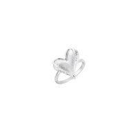 Silver ring with 3D heart formed by textured feather-like elements, white gold plated eco-brass on neutral background.