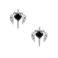 Silver drop earrings with twisted hoops and angel wings embracing black heart locket on white background.