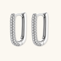 Close-up of platinum-plated sterling silver huggie hoops with pavé crystal setting on white background.